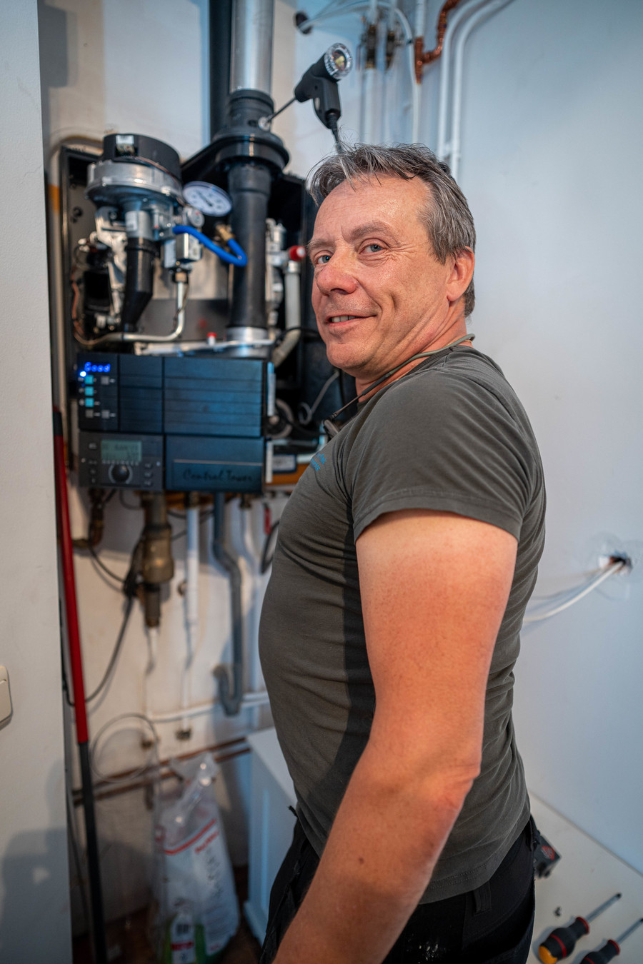 Frank Lamberechts kijkt naar de camera met achter hem een installatie