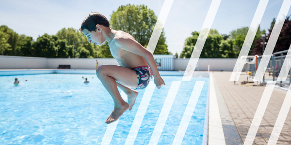 Een jongetje springt in het groot bad van zwembad De Molen op Linkeroever
