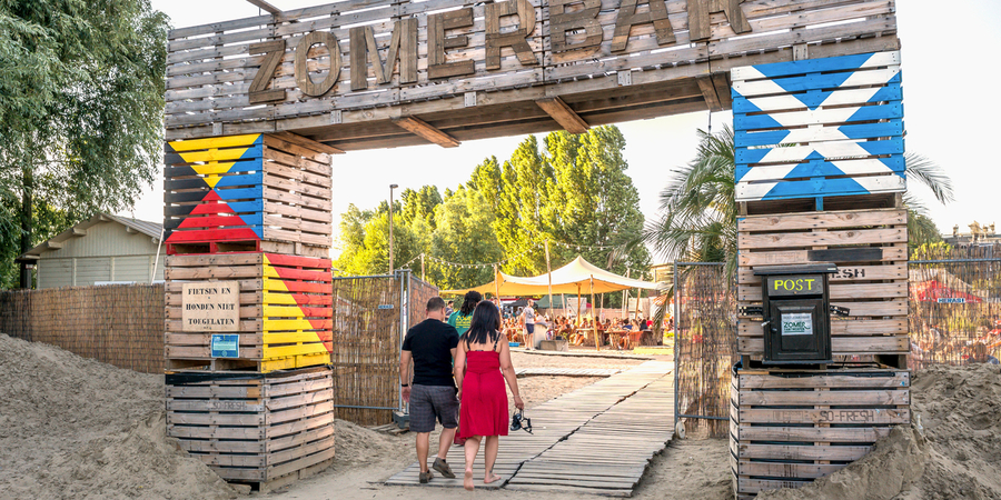 Een man en een vrouw wandelen samen de Zomerbar binnen van Zomer van Antwerpen. Een man en een vrouw wandelen samen de Zomerbar binnen van Zomer van Antwerpen.