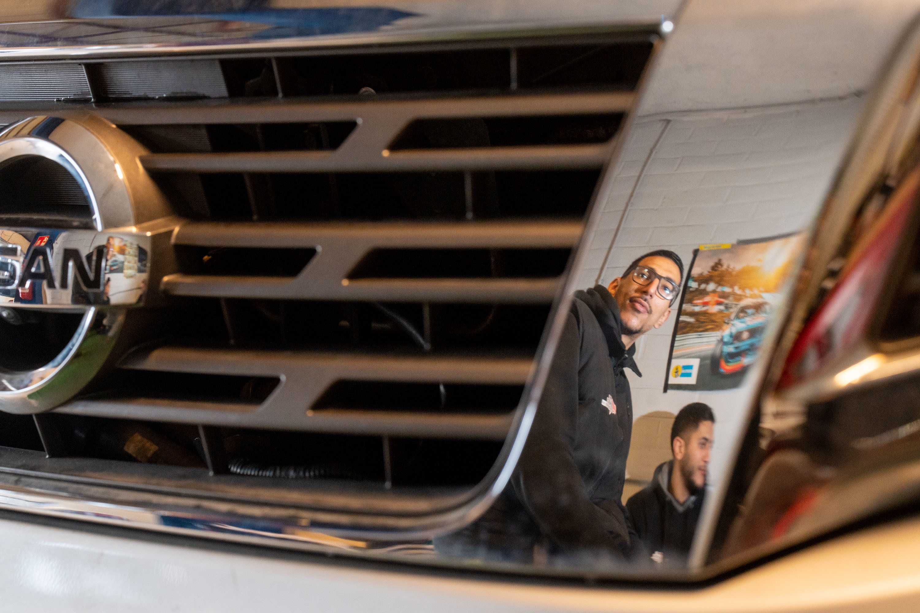 Weerspiegeling van het duo in de chroomafwerking van het front van een wagen Weerspiegeling van het duo in de chroomafwerking van het front van een wagen