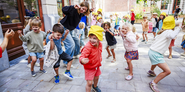 Kinderen spelen samen een uitbeeldingsspelletje op een koer in de zomer