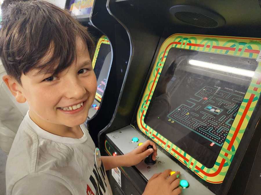 kind speelt op arcade kast kind speelt op arcade kast