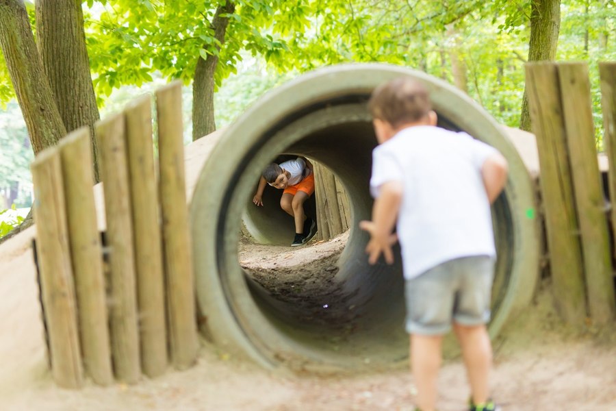 Kinderen spelen in buizen aan de Bossafari