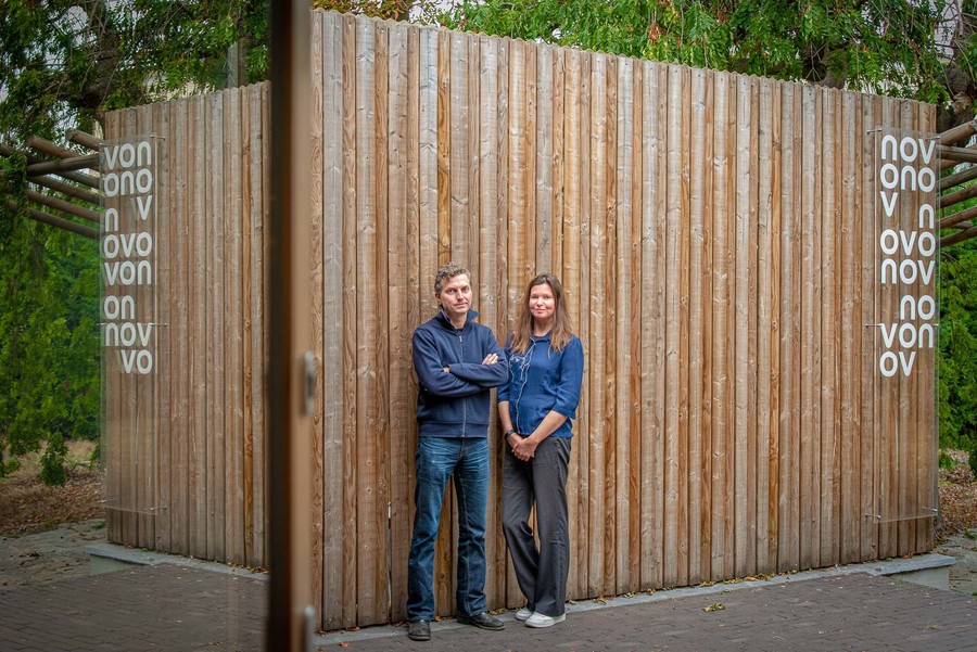 Benjamin en Liesbeth aan de houten schutting in de tuin