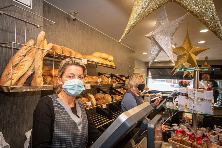 Met mondmasker achter kassa