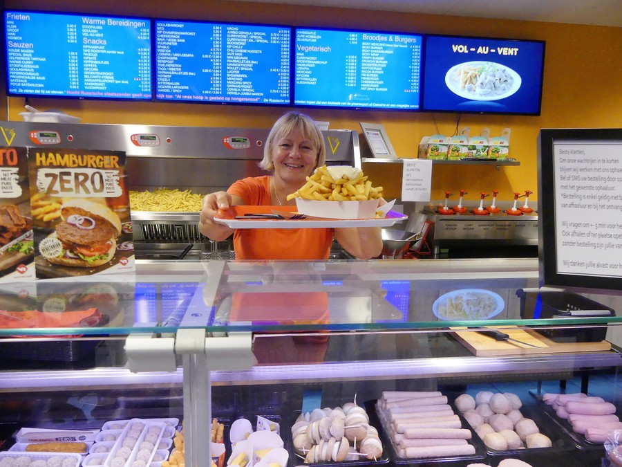 Marina serveert de frietjes over de toog