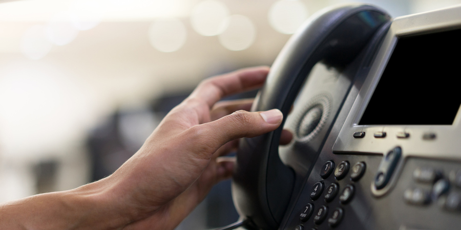 Een hand neemt een telefoon op. Een hand neemt een telefoon op.