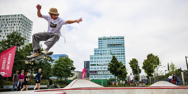 Skateboarder doet trucje in skatebowl met ziekenhuis Cadix op achtergrond