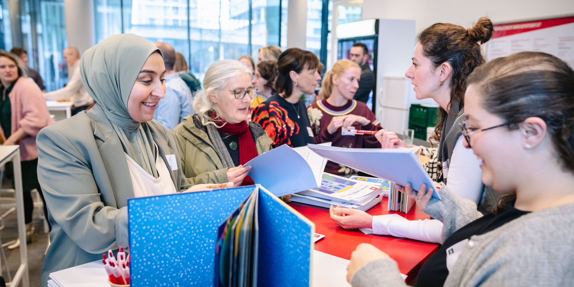 Bezoekers lezen in brochure aan infostand