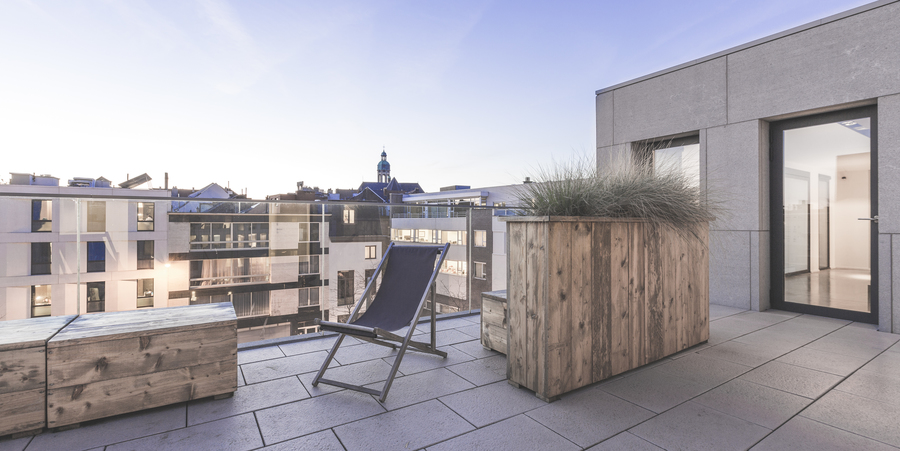 Dakterras met strandstoel en zicht op de Antwerpse binnenstad.