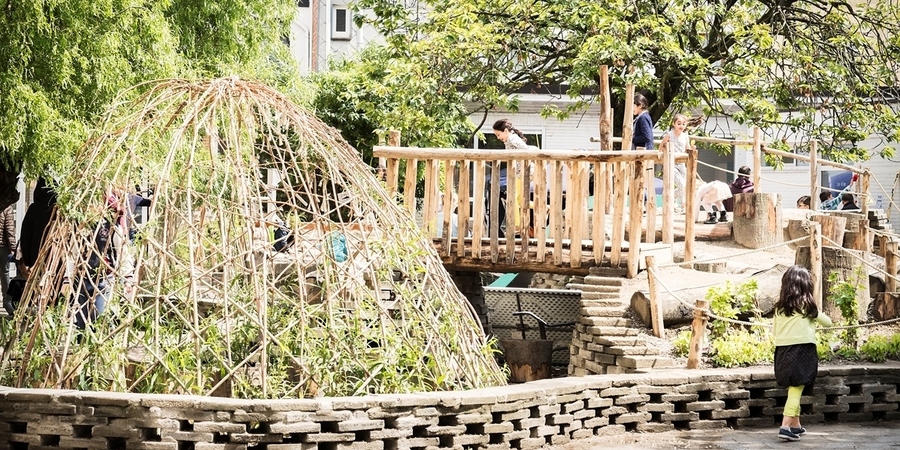 Groene speelplaats met wilgenhut en bruggetje Groene speelplaats met wilgenhut en bruggetje