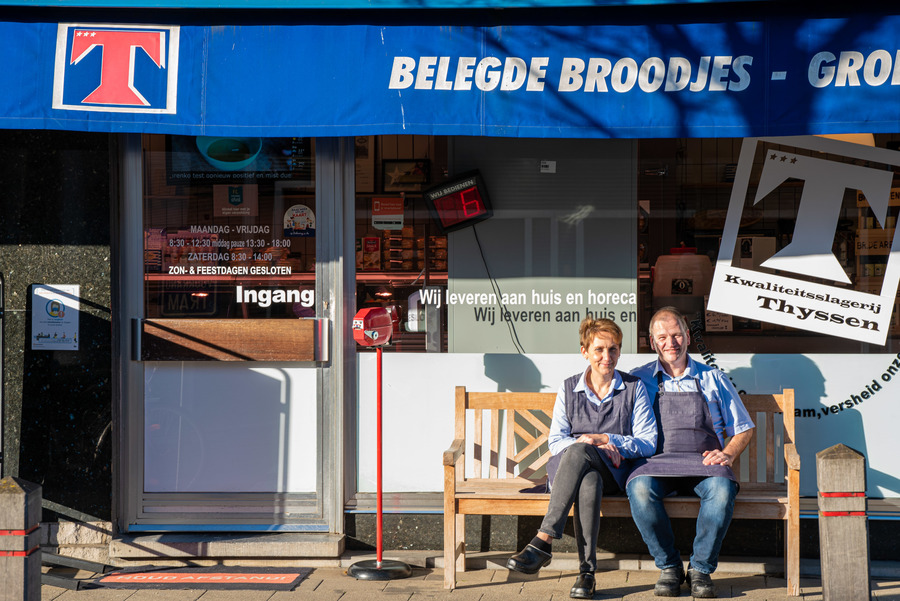 Katrien en Chris op een bankje buiten voor de winkel