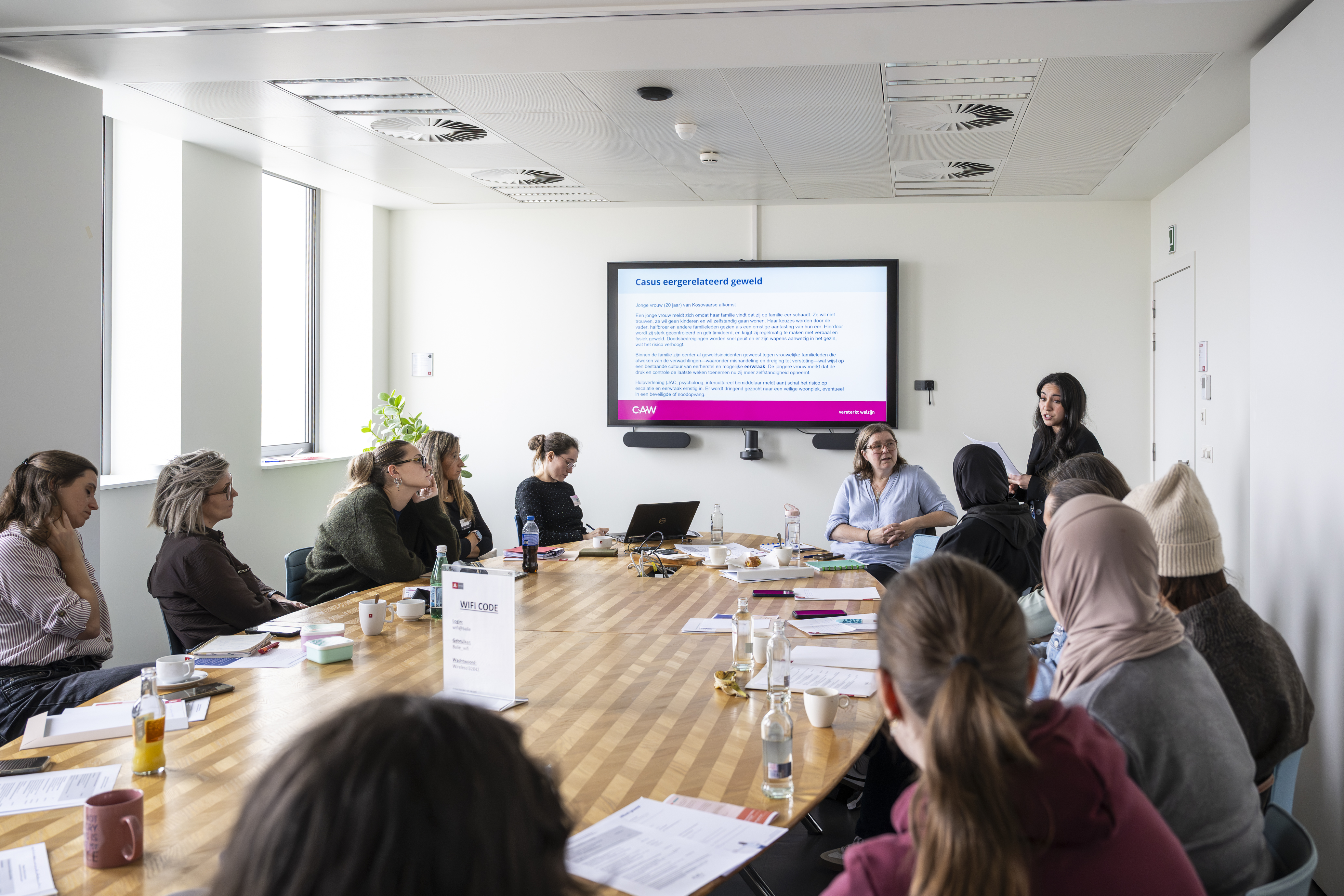 Mensen zitten rond tafel in vergaderzaal