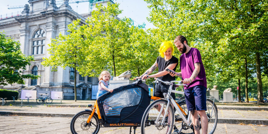 Man, vrouw en kind met fiets en bakfiets aan het KMSKA Man, vrouw en kind met fiets en bakfiets aan het KMSKA