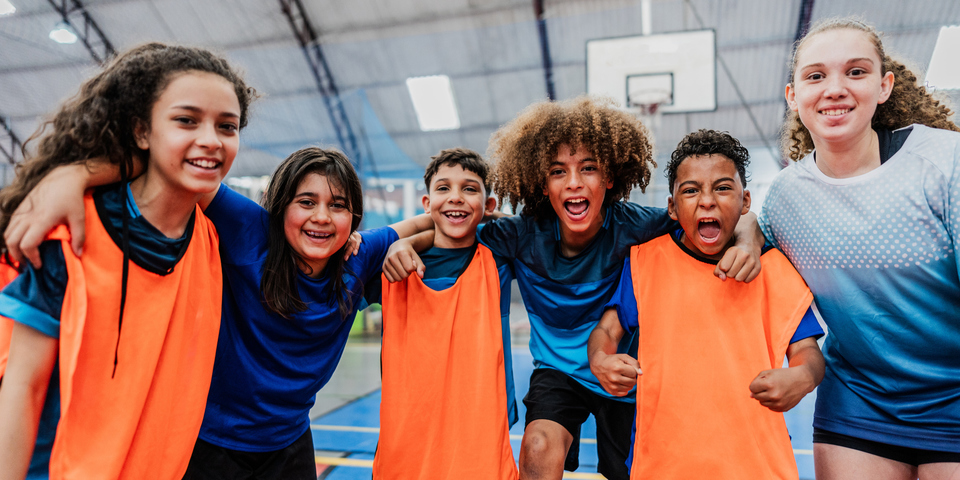 groep jongeren die in een sporthal staan