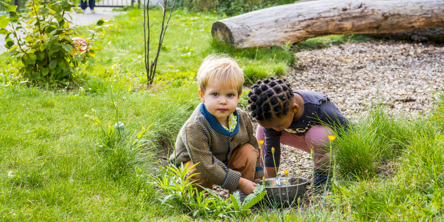 Twee kinderen spelen in de natuurlijke buitenruimte van kinderdagverblijf Brabbel Twee kinderen spelen in de natuurlijke buitenruimte van kinderdagverblijf Brabbel
